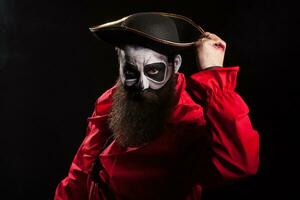 Bearded and spooky medieval pirate with blood on his hands over black background. Halloween disguise. photo