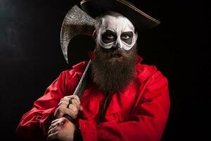 Medieval captain holding an axe over black background. Halloween outfit. photo
