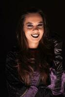 joven mujer con un bruja atuendo para Víspera de Todos los Santos terminado negro antecedentes foto