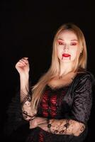 mujer con vampiro rojo vestir para Víspera de Todos los Santos. misterio mujer. foto