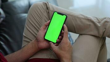 smartphone groen scherm in hand, een heren hand- is Holding een telefoon. video