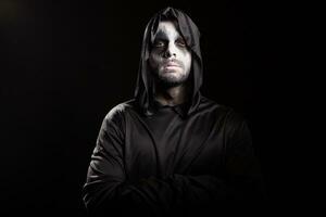Thoughtful grim reaper over black background. Spooky monster. photo
