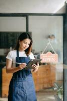 Startup successful small business owner sme woman stand with tablet  in cafe restaurant. woman barista photo