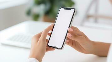 Close up view businessman holding smart phone with blank screen while standing in modern office. photo