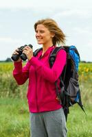 Woman  hiker with binoculars in nature photo