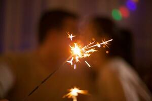 Adorable caucasian couple holding bengal lights on christmas day. photo