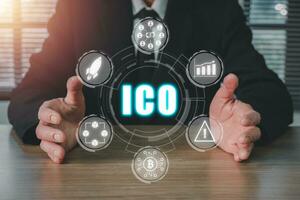 ICO, Initial Coin Offering concept, Businessman hand holding Initial Coin Offering icon on virtual screen, Digital electronic binary money financial, Business, Technology, Internet and network. photo