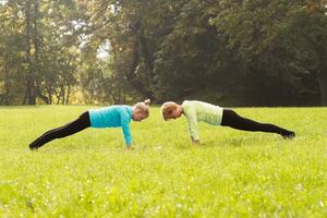 Two woman doing yoga in nature. photo