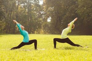 Two woman doing yoga in nature. photo