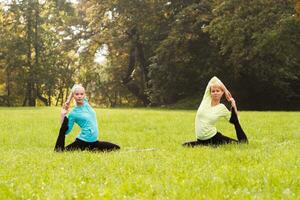 Two woman doing yoga in nature. photo