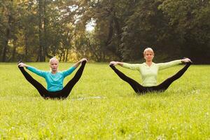 Two woman doing yoga in nature. photo