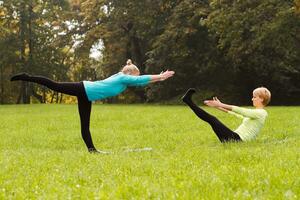 Two woman doing yoga in nature. photo