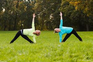 Two woman doing yoga in nature. photo