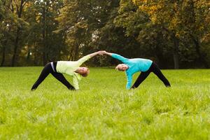 Two woman doing yoga in nature. photo