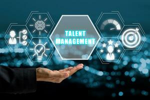 Talent management concept, Business woman hand holding talent management icon on virtual screen with blue bokeh background. photo