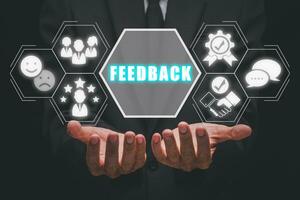 Feedback concept, Businessman hand holding feedback icon on virtual screen. photo