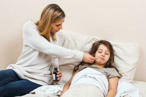 pequeño niña es teniendo gripe y madre es tomando cuidado de su foto