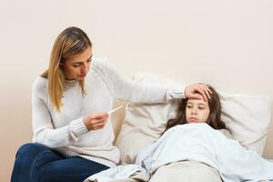 pequeño niña es teniendo gripe y madre es tomando cuidado de su foto