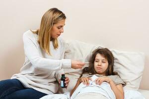 pequeño niña es teniendo gripe y madre es tomando cuidado de su foto