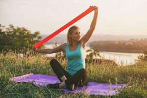 Beautiful sporty woman exercise with rubber band photo