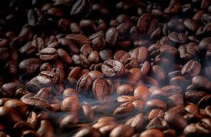 Roast coffee beans with faint smoke or steam from baking. Roast coffee beans before blending or grinding them to make fresh coffee, espresso or drip. photo