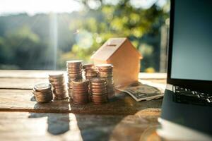 Saving money home, stacked money and savings house on the table photo