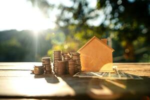 Saving money home, stacked money and savings house on the table photo