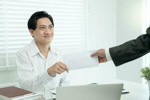 Businessmen receive salary or bonuses from management or Boss. Company give rewards to encourage work. Smiling businessman enjoying a reward at the desk in the office. photo