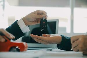 Closeup asian male people car salesman or sales manager offers to sell a car and explains and reads the terms of signing a car contract and insurance. photo