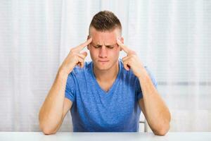 Young man is having strong headache. photo