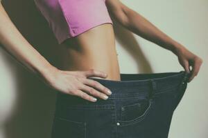 Woman in large jeans.Weight loss concept.Toned photo. photo