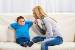 Angry mother is scolding at her son. photo