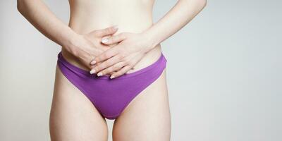 woman in panties holding belly with abdominal or period pains photo