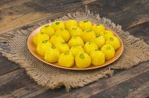 Indian Traditional Yellow Sweet Food Coconut Laddoo on Wooden Background photo