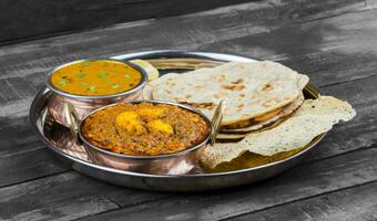 indio tradicional thali comida kadai Queso indio servido con dal makhani en Clásico de madera antecedentes foto