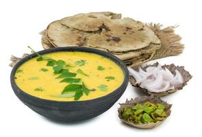 Rajasthani And Gujarati Traditional Cuisine Kadhi or Bajra Roti on White Background photo