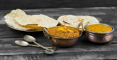 indio comida kadai Queso indio servido con dal makhani, tandoori o papad en de madera antecedentes foto