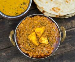 Indian Food Kadai Paneer Served With Dal Makhani, Tandoori or Papad on Wooden Background photo