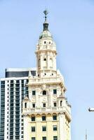 the building is tall and has a clock on top photo