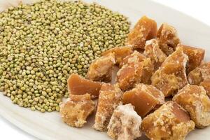 Group of jaggery with Coriander Seeds on White Background photo