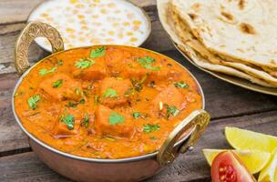 Indian Delicious Cuisine Paneer Tikka Masala With Tandoori Chapati on Wooden Background photo