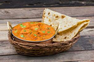 Indian Delicious Cuisine Paneer Tikka Masala With Tandoori Chapati on Wooden Background photo