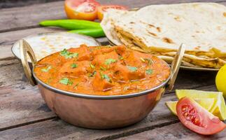 Indian Delicious Cuisine Paneer Tikka Masala With Tandoori Chapati on Wooden Background photo