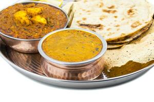 Indian Traditional Thali Food Dal Makhani Served with Chapati, Papad, Kadai Paneer or Lemon on White Background photo