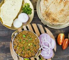 Indian Cuisine Sev Tamatar on Wooden Table photo