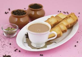 Indian Popular Drink Masala Chai or Masala Tea on Pink Background photo