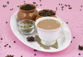 Indian Popular Drink Masala Chai or Masala Tea on Pink Background photo