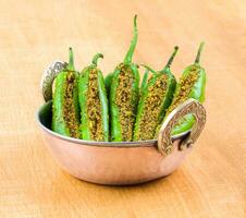 Indian Spicy Green Chilli Pickle on Wooden Background photo