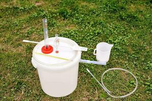 a bucket with a hose and a pitcher sitting on the grass photo