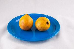 two ripe mangoes on a blue plate photo